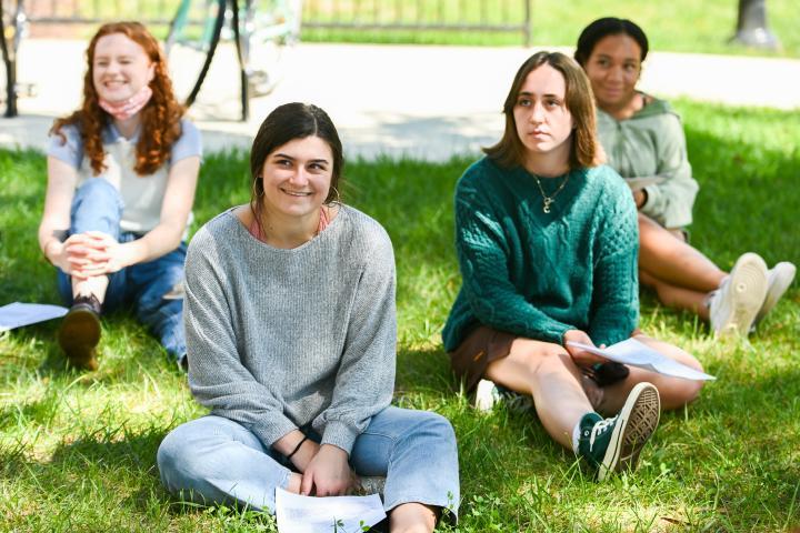 人文学生在外面的草地上听老师讲课